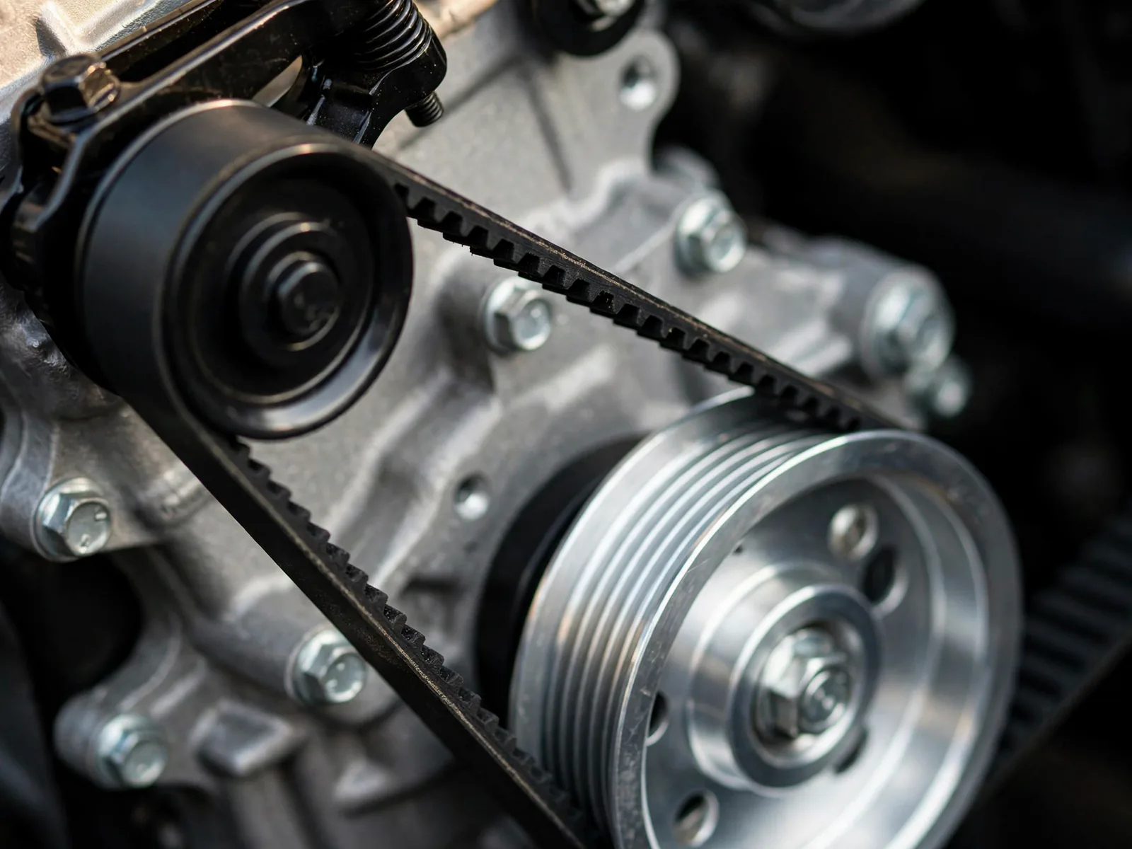 Close detail of an engine's belts and pulleys